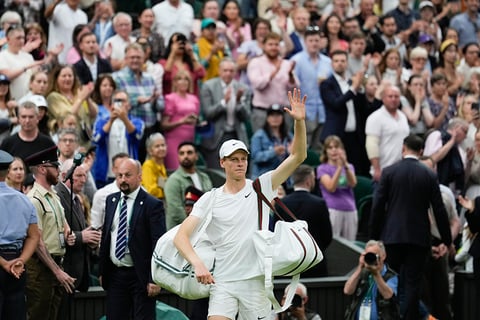 Jannik Sinner waves as he leaves the court following his quarterfinal loss to Daniil Medvedev 